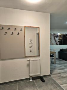 una parete con uno specchio e un termosifone in una stanza di Apartman Prijedor a Prijedor Altre 8 foto