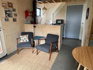 a room with two chairs and a table and a counter at De Tuinkamer in Ouddorp