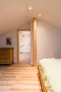 a bedroom with a bed and a wooden dresser at Ferienhaus am Eichberg in Grabenstätt