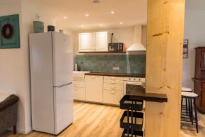 a kitchen with a white refrigerator and a table at Ferienhaus am Eichberg in Grabenstätt