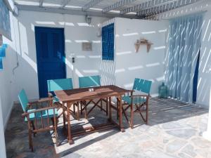 a wooden table and chairs on a patio at Akrogiali studios in Donoussa