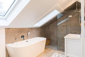 a bathroom with a bath tub and a sink at Ferienhaus am Eichberg in Grabenstätt