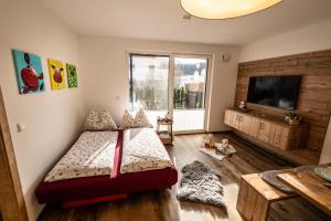 a bedroom with a bed and a flat screen tv at Apartment Motzenhof - Stadtnähe Salzburg - modernes Bauernhoferlebnis inklusive in Adnet +49 photos