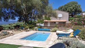 a backyard with a swimming pool and chairs and a house at A Casa Faggia in Sollacaro