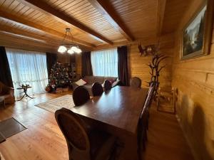 a living room with a table and a christmas tree at WOOD house in Skhidnitsa