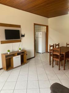 a kitchen and dining room with a table and a refrigerator at Apartamento Day in Ilhéus