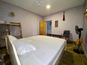 a bedroom with a large white bed in a room at HIGSAM apartment in Diani Beach