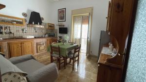 a living room with a table and a kitchen at Nuova Netum apartment in Noto
