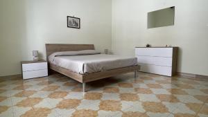 a bedroom with a bed and a dresser at Nuova Netum apartment in Noto +1 photo