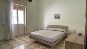a bedroom with a bed and a table and a window at Nuova Netum apartment in Noto