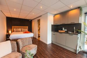 a hotel room with a bed and a kitchen and a room at Tiny Boat House #5 in Garnwerd +13 photos