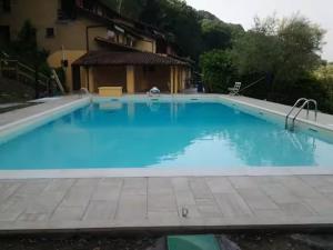 a large blue swimming pool next to a building at Baia dei Colori in Cure