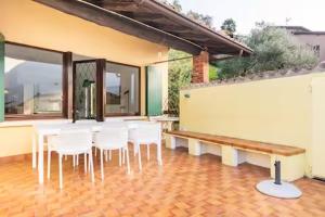 a room with a table and chairs and a bench at Baia dei Colori in Cure