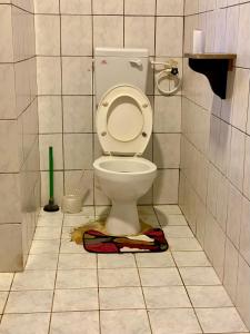 a bathroom with a toilet with a towel on the floor at HIGSAM apartment in Diani Beach