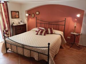 a bedroom with a bed with a red wall at comodo e rilassante in Ucria +4 photos