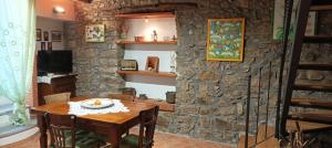 a dining room with a table and a stone wall at comodo e rilassante in Ucria