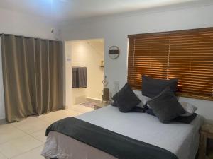 a bedroom with a large bed and a bathroom at The Little Gem in Clanwilliam