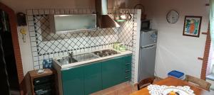 a kitchen with a sink and a refrigerator at comodo e rilassante in Ucria