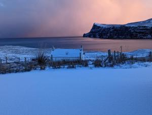 een met sneeuw bedekt veld met een hek en een met sneeuw bedekt meer bij Lon Ban House B&B in Glendale +81 foto's
