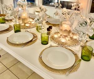 a white table with plates and candles on it at The Sullies in Morganʼs Bay +25 photos