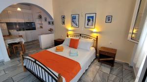 a bedroom with a bed with an orange blanket at Akrogiali studios in Donoussa