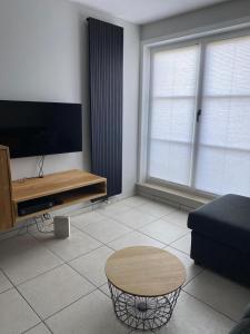 a living room with a tv and a coffee table at Residentie Sofie in Koksijde