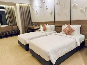 a hotel room with two beds and a couch at Windmill Upon Hills Genting Highland by El Naura in Genting Highlands +5 photos
