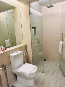 a bathroom with a toilet and a glass shower at Windmill Upon Hills Genting Highland by El Naura in Genting Highlands