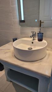 a white sink in a bathroom with a mirror at Akrogiali studios in Donoussa +58 photos