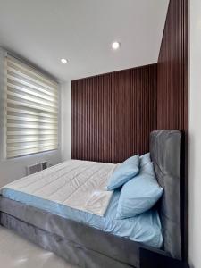 a bedroom with a large bed with a wooden wall at Vibe and Stay - Staycation home near Tagaytay in Calo