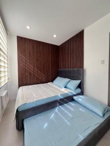 a bedroom with two beds and a wooden wall at Vibe and Stay - Staycation home near Tagaytay in Calo