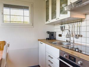 a white kitchen with a sink and a window at Lundenbergsand in Simonsberg