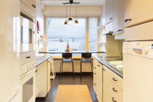 a kitchen with a large window and a counter with stools at Aurora Family Suite in Rovaniemi +26 photos