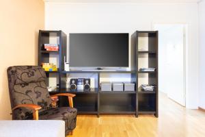 a living room with a tv and a chair at Aurora Family Suite in Rovaniemi