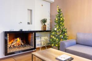 a living room with a christmas tree and a fireplace at Aurora Family Suite in Rovaniemi