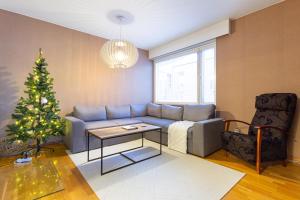 a living room with a christmas tree and a couch at Aurora Family Suite in Rovaniemi