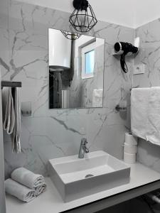 a white bathroom with a sink and a mirror at Apartment Viktor in Sali