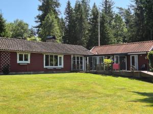 a red house with a yard in front of it at Åker Lilläng Solviken in Skillingaryd