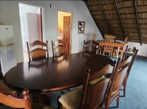 a dining room with a wooden table and chairs at De Kleine Kaap Guesthouse in Lady Grey