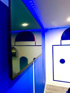 una stanza blu con uno scaffale con un quadro sopra di WORLDROOM Chambre privée avec espace commun a Perpignano