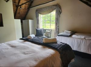 a bedroom with two beds and a window with a laptop at De Kleine Kaap Guesthouse in Lady Grey +80 photos