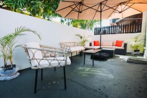 a patio with couches and an umbrella and plants at Aintree Bungalow in Portmore