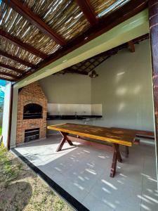 Eine Holzbank auf einer Terrasse mit Kamin in der Unterkunft Pousada Melk Beach in Luis Correia