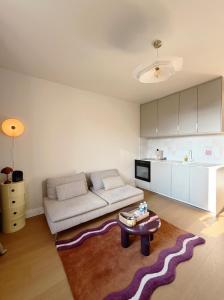 een woonkamer met een bank en een tafel bij Le Ptit Rennes- 200 m de la Gare Cosy Lumineux in Rennes