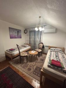 una stanza con due letti, un tavolo e delle sedie di Stara Ruža a Gračanica