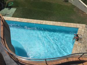 een uitzicht over een zwembad met een persoon erin bij Costeira Praia - Belo Flat in Natal