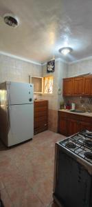 a kitchen with a white refrigerator and a stove at Spacious Villa with Pool and Sea View in Dawwār ‘Abd Allāh