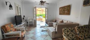a living room with a couch and a tv at Spacious Villa with Pool and Sea View in Dawwār ‘Abd Allāh