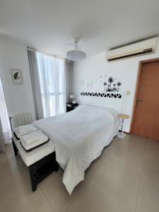 a bedroom with a large white bed and a window at Apartamento Ejecutivo Premium Riviera Tower in Villa Carlos Paz