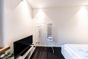 een witte kamer met een glazen plank aan de muur bij Lea Apartement - Ruhiges Studio in Schaffhausen